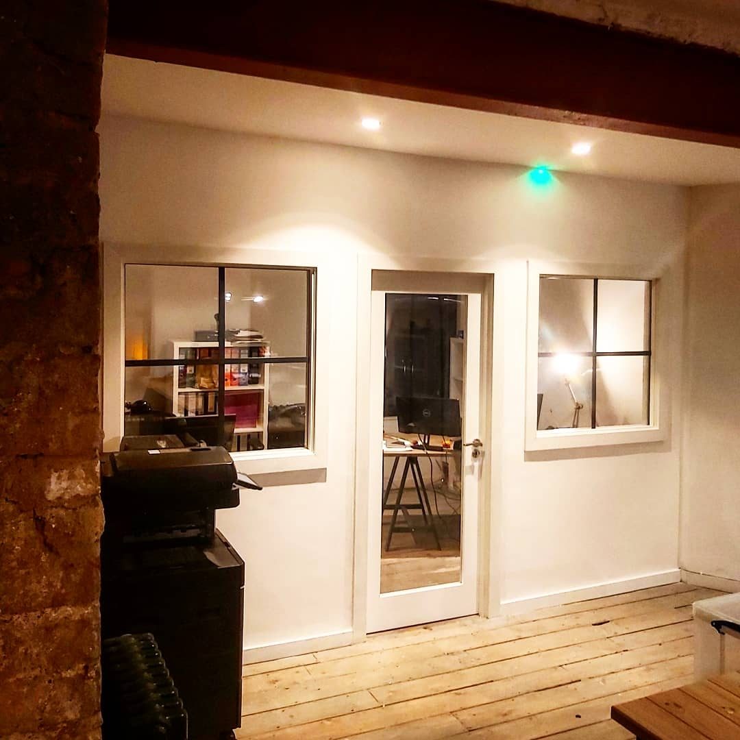 The glazed partition wall at night, lit from inside