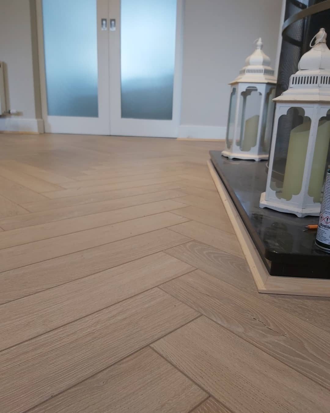 A herringbone floor running up to a raised hearth and glazed double doors