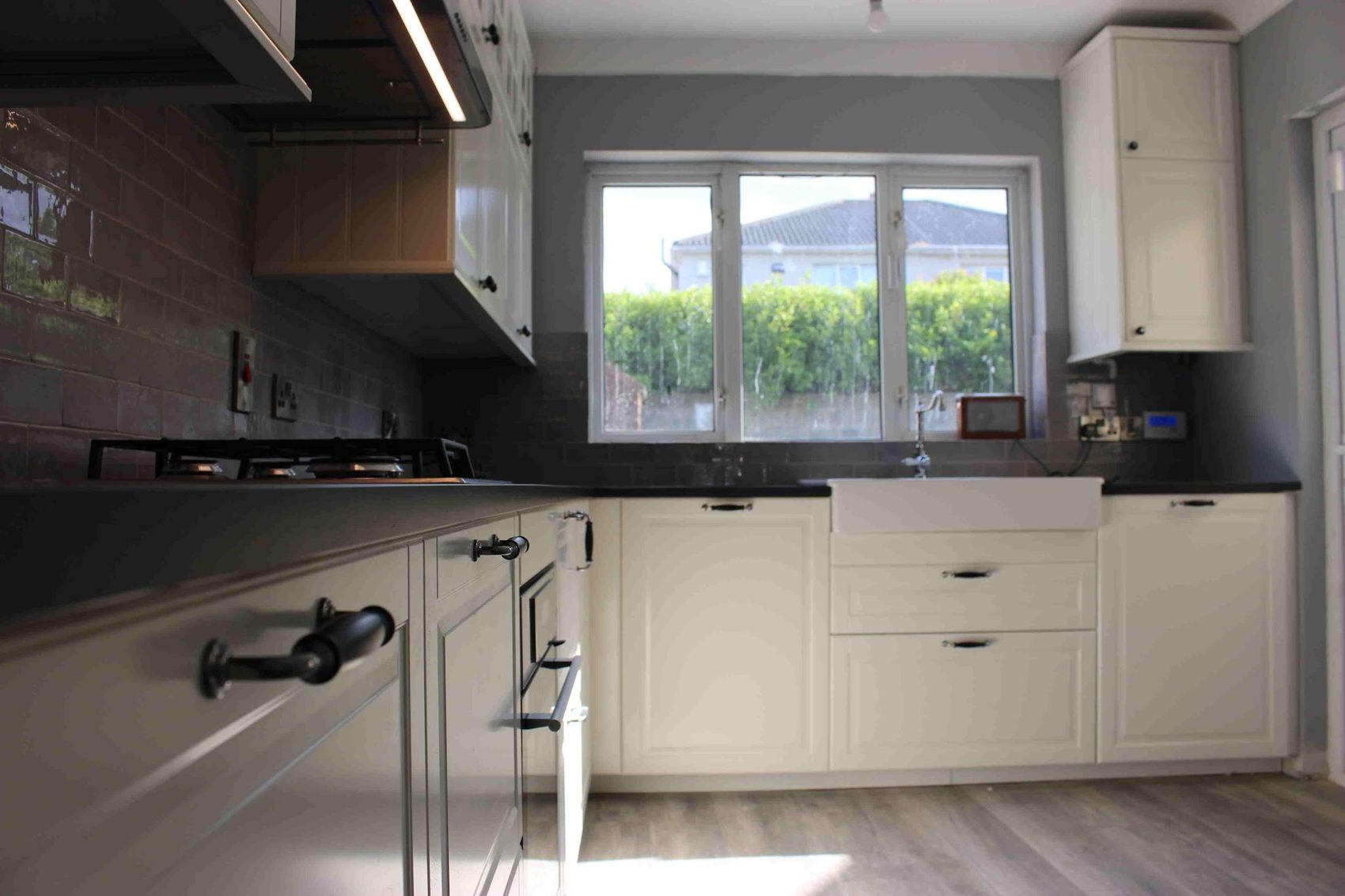 The white shaker kitchen from the window end, with a belfast sink